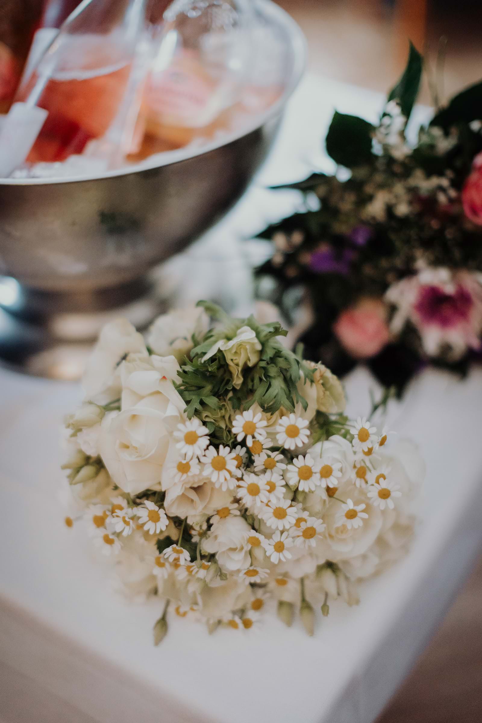 Brautstrauß aus weißem Lisianthus und Mutterkraut auf dem Empfangstisch im Stavenhagenhaus