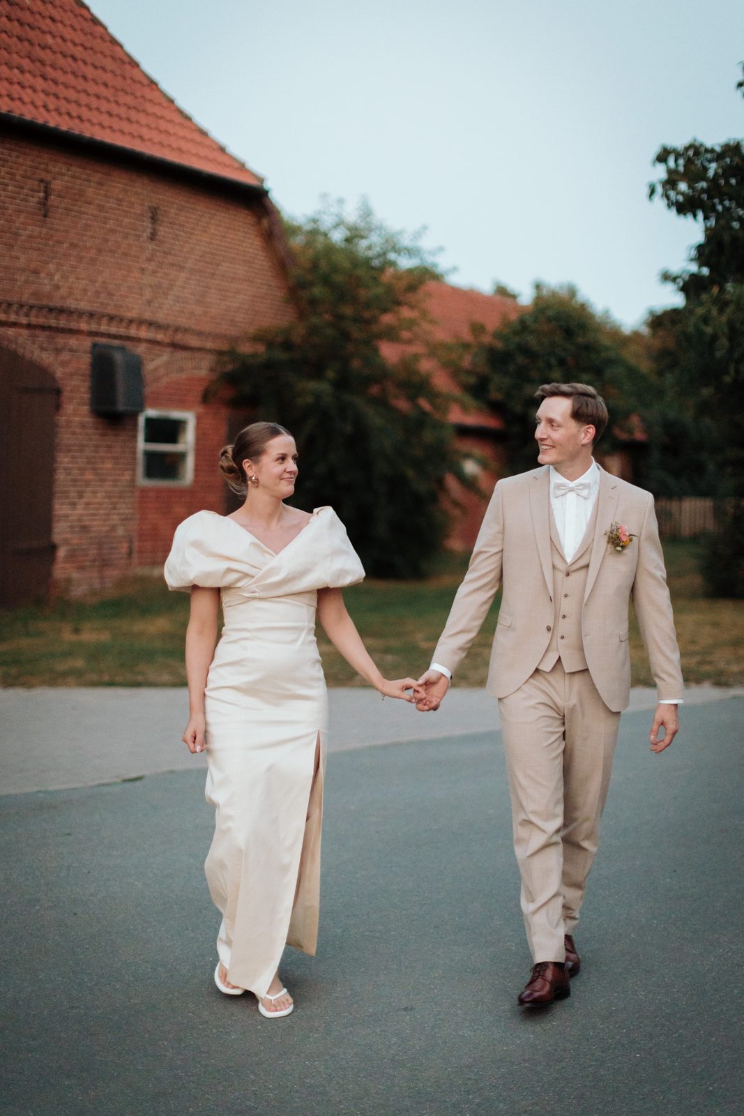 Jana und Sören laufen Hand in Hand die Straße entlang